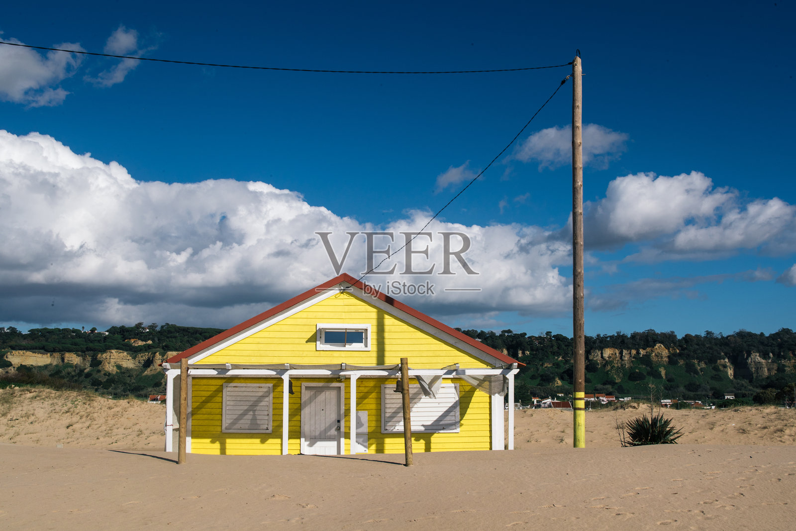 卡帕里卡，里斯本，葡萄牙。2023年12月2日。大西洋海岸沙丘旁的沙滩小屋，拥有红色和黄色外墙照片摄影图片
