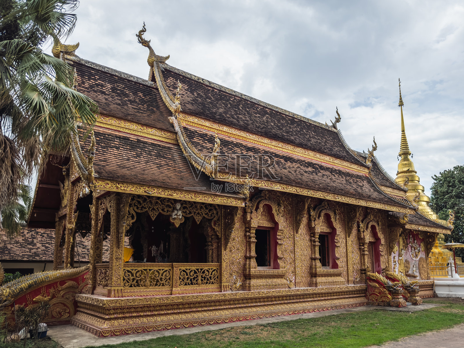 泰国清莱的华光寺内一座精致的金色寺庙，展示着兰纳佛教的传统建筑风格，拥有精美的雕刻、多层屋顶和充满活力的文化遗产。照片摄影图片