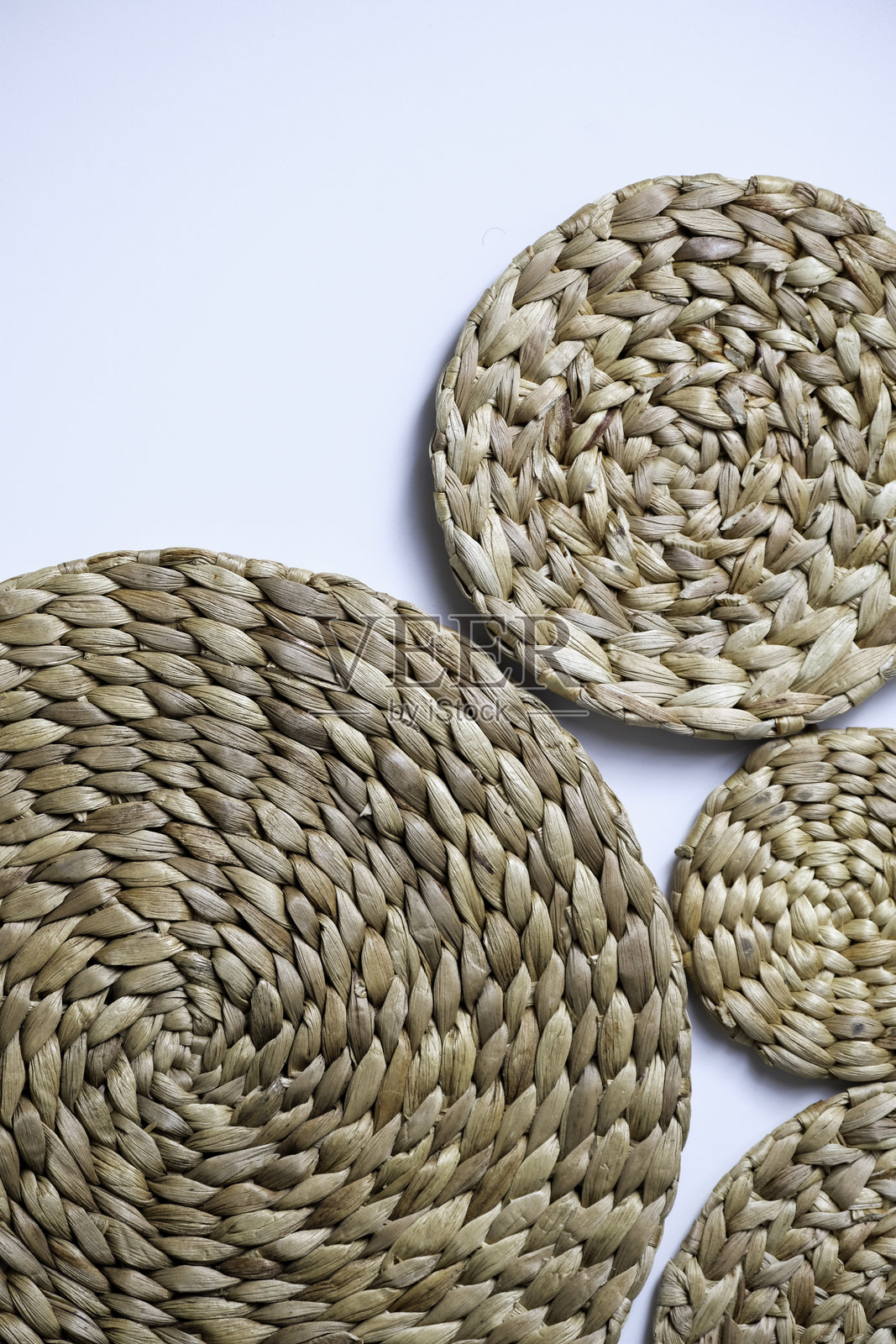 圆形的天然水葫芦编织餐垫，白色背景上孤立照片摄影图片