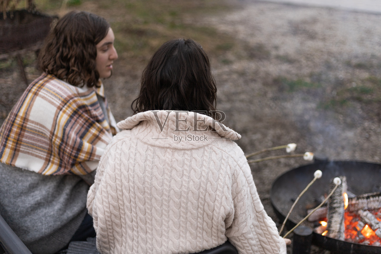 两个年轻女子在篝火旁烤棉花糖照片摄影图片