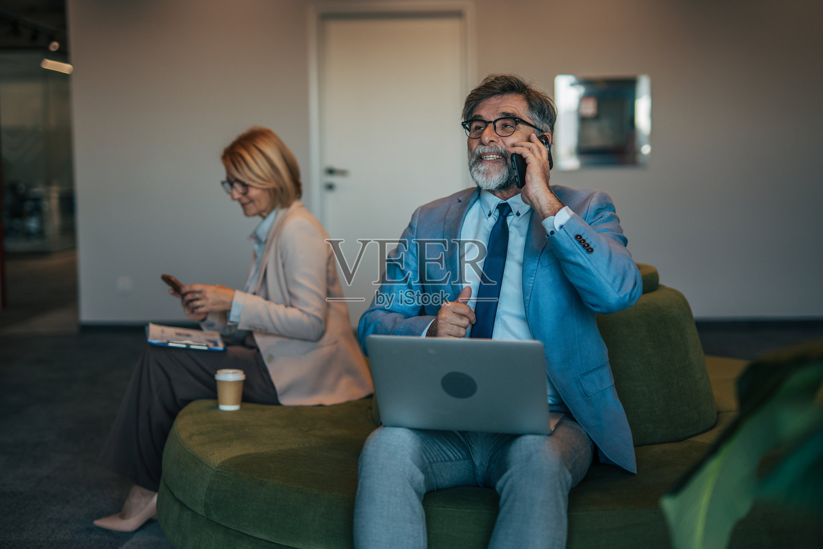 成熟的商务人士在办公室休息区远程工作照片摄影图片