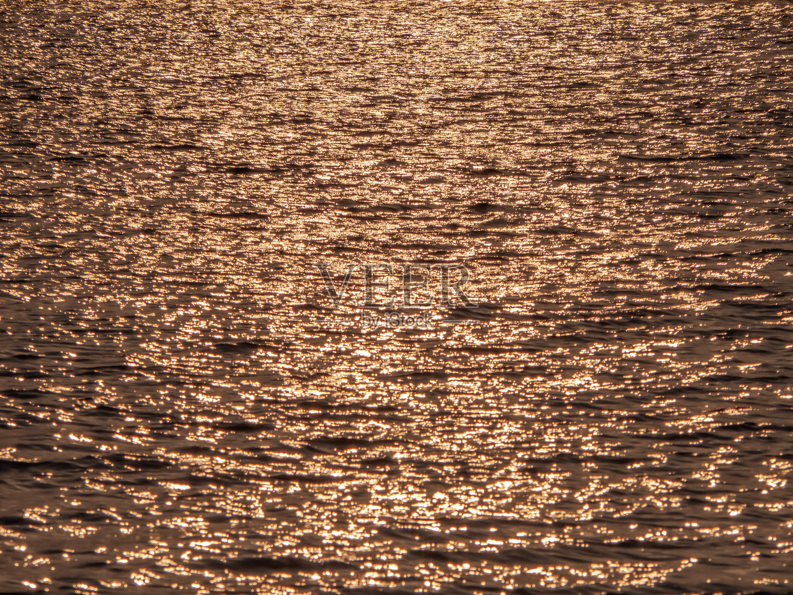 夕阳下闪耀着金光的湖面照片摄影图片