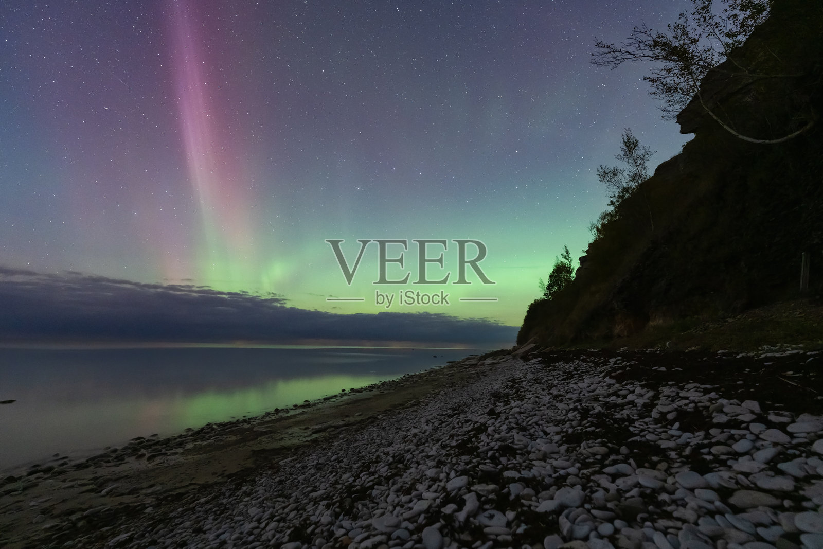 爱沙尼亚帕尔迪斯基，波罗的海上空，绚丽的北极光闪耀，呈现出绿色和紫色的光芒，海面平静。照片摄影图片