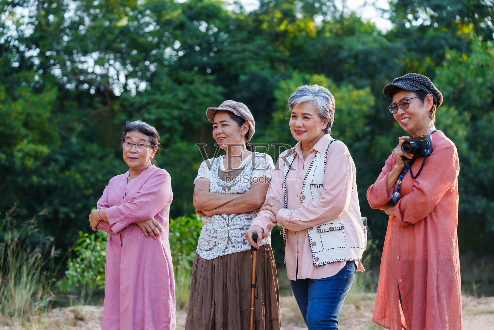年长的亚洲女性们在户外穿着休闲服饰，面带笑容，姿态愉悦，享受着自然、假期、旅行、冒险、自由、休闲、生活方式、清新、探索、友谊、旅程和幸福的时光。照片摄影图片