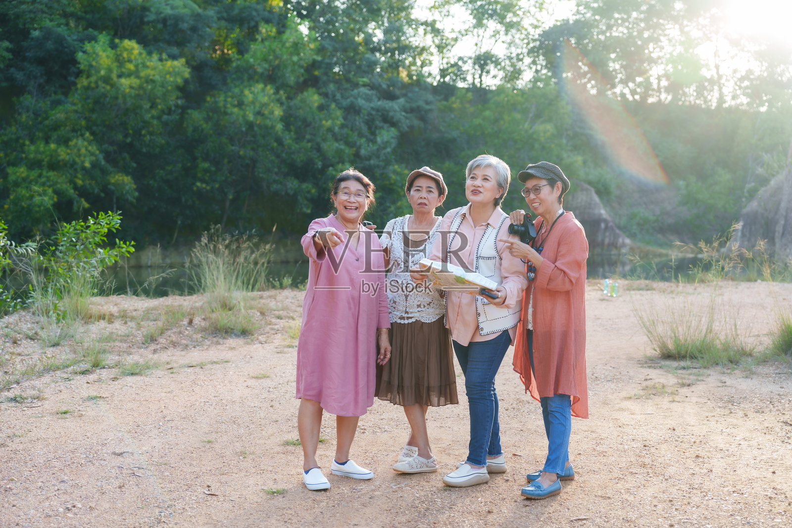 一群年长的亚洲女性，身着休闲服饰，在户外享受大自然探险的乐趣，她们面带笑容，看起来心情愉悦，仿佛正在度假旅行，享受着自由自在的生活方式，这段放松惬意的休闲时光充满了友谊。照片摄影图片