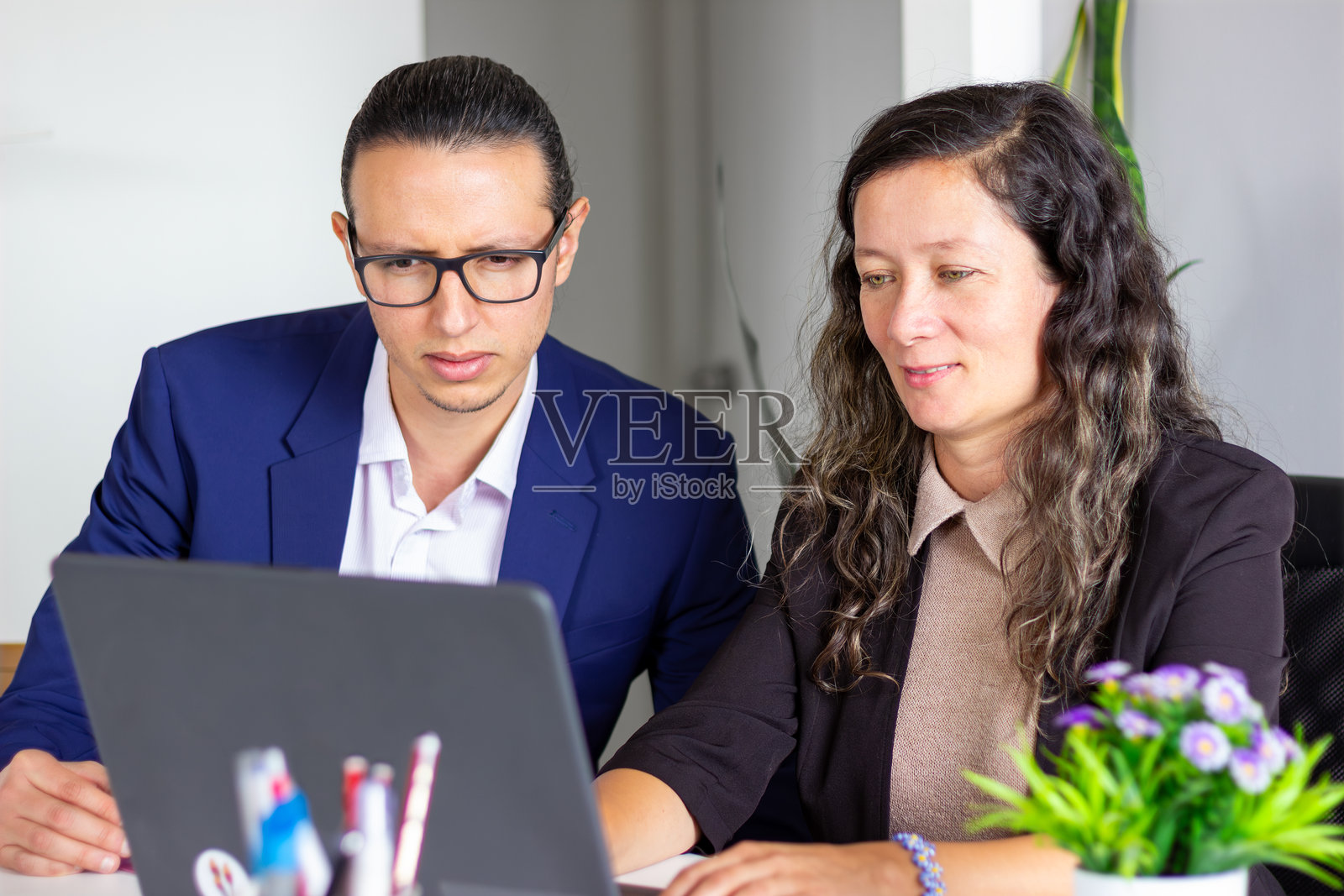 两位商务专业人士在笔记本电脑上协作照片摄影图片
