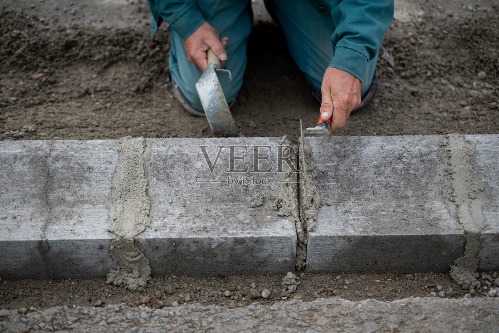 工人正在安装带有砂浆的混凝土路缘石照片摄影图片