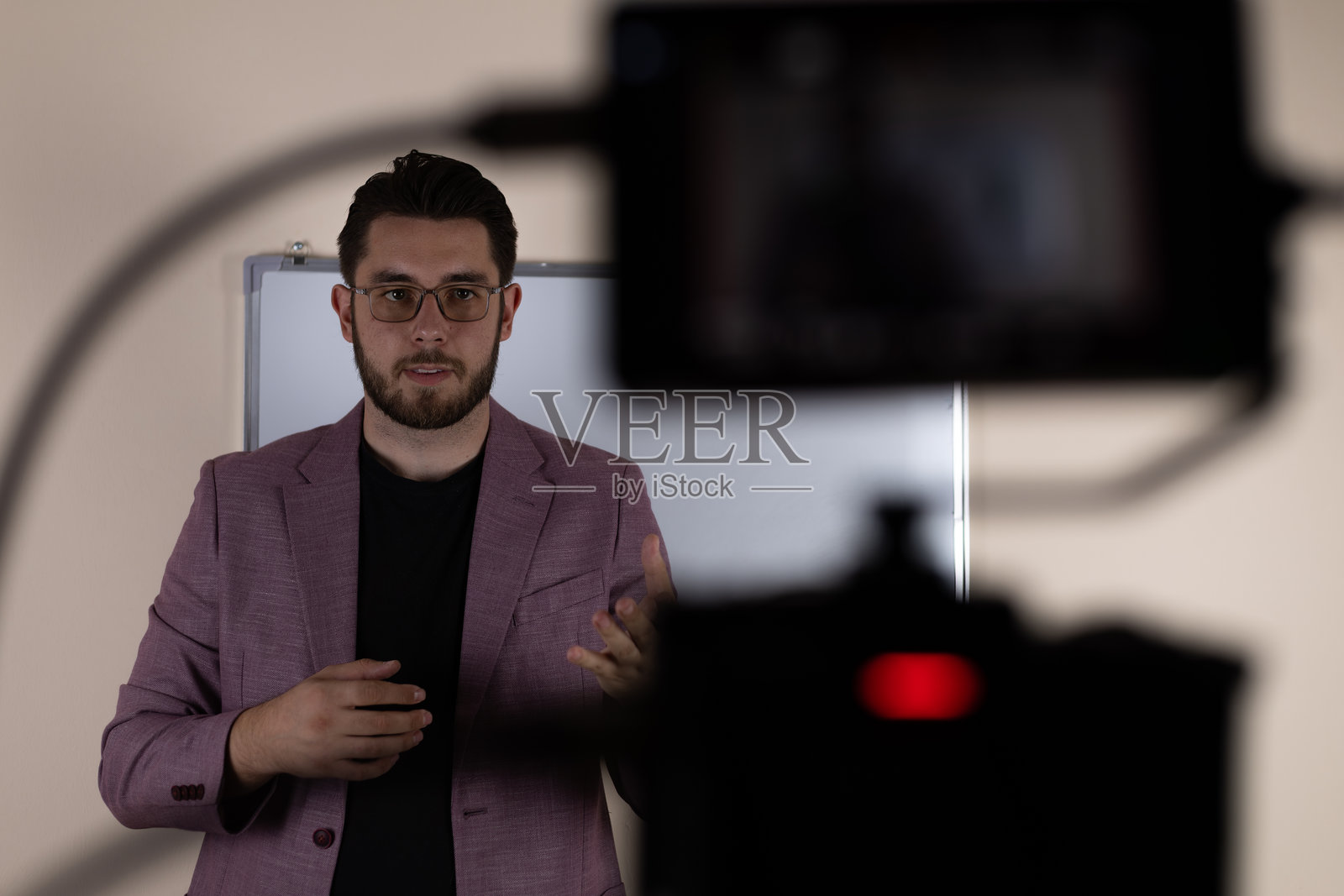 男人正在录制一期播客节目，直接对着镜头讲话照片摄影图片