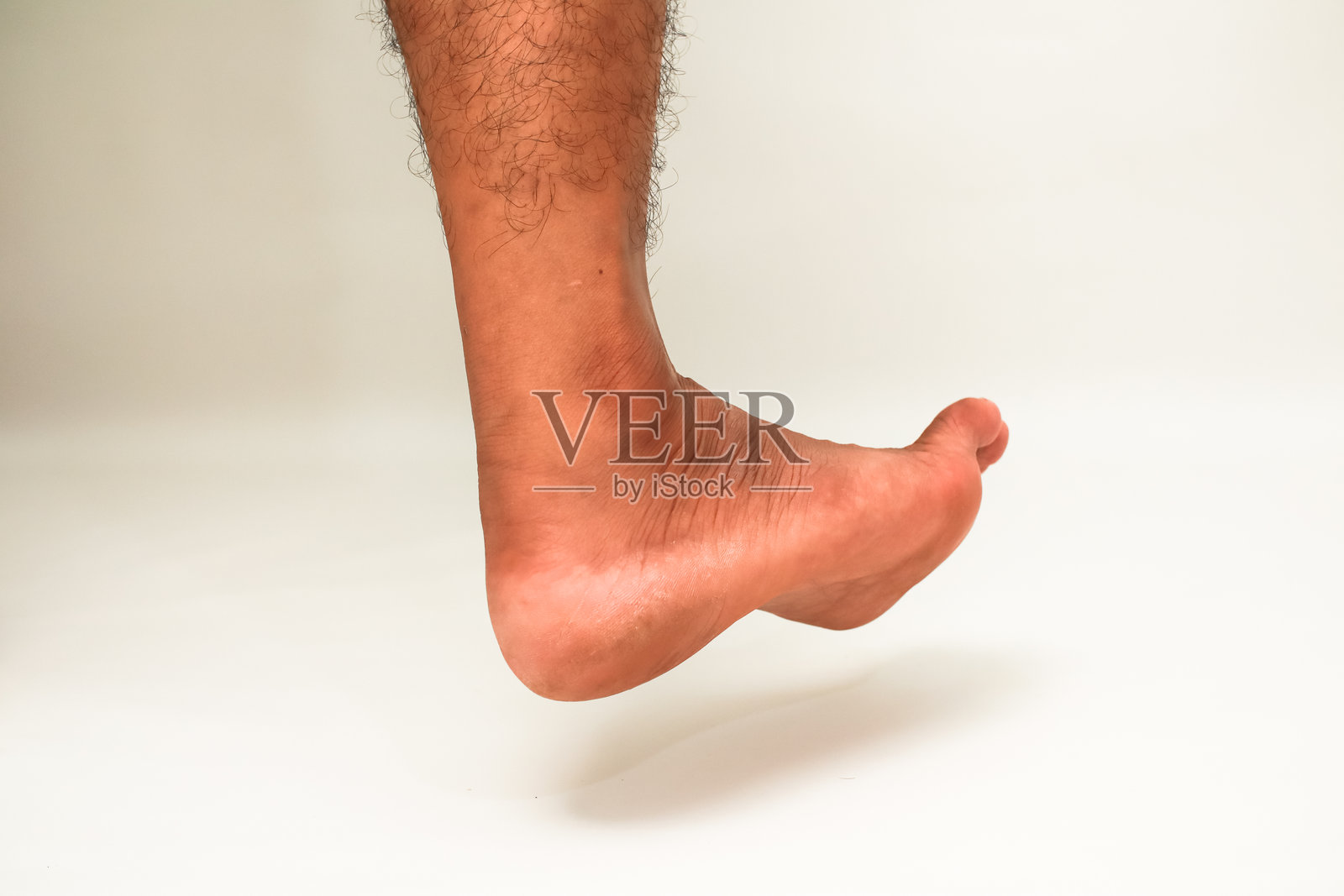 特写镜头展示了白色背景下的人类脚踝，突出其运动性和柔韧性照片摄影图片