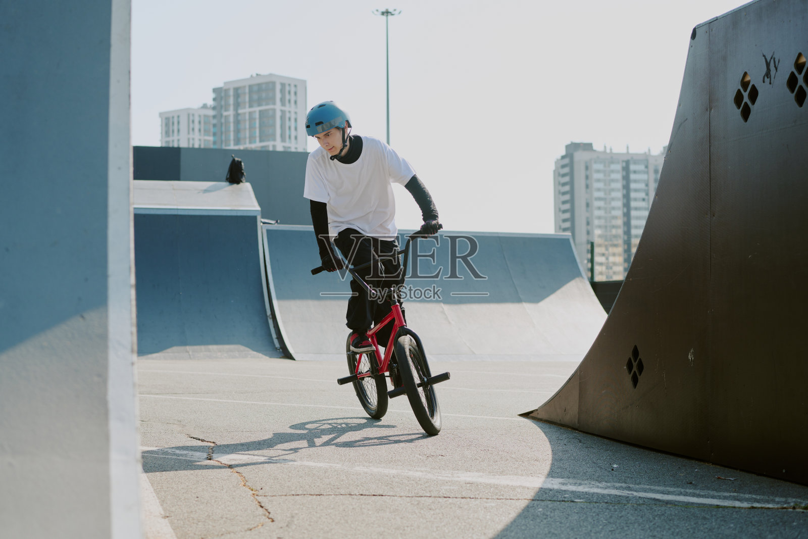 青少年在城市滑板公园骑BMX自行车表演特技照片摄影图片