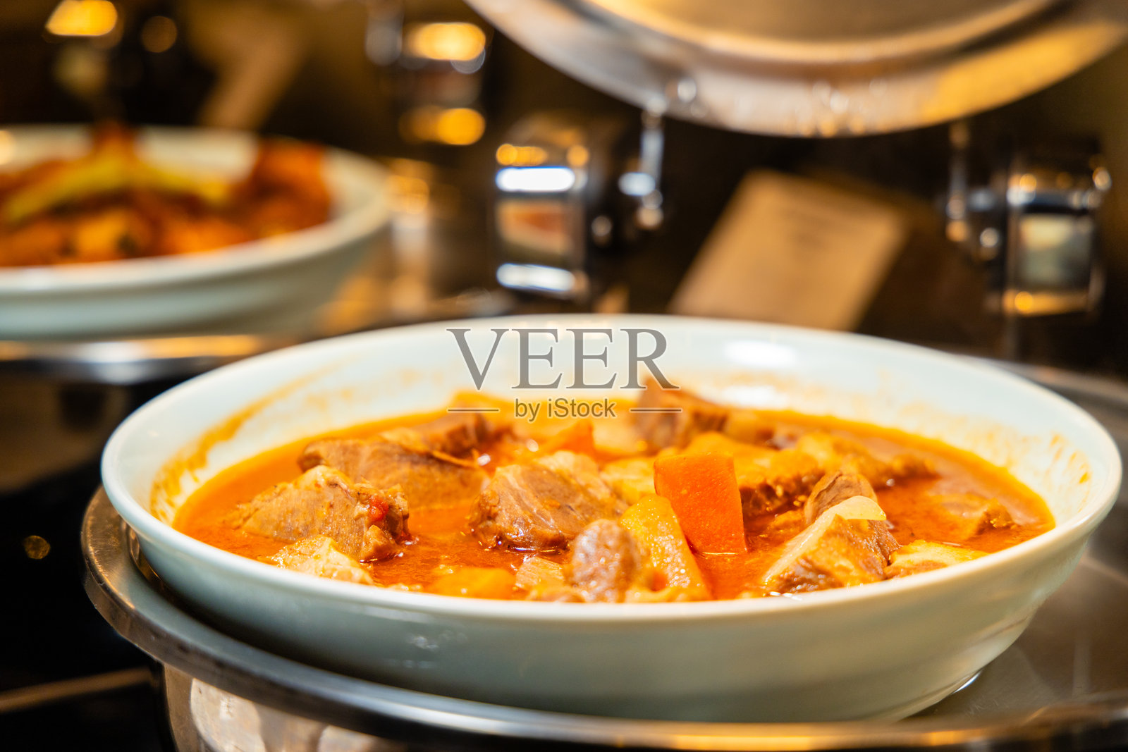 白碗中盛着丰盛的炖牛肉，味道浓郁，非常适合在寒冷天气享用照片摄影图片