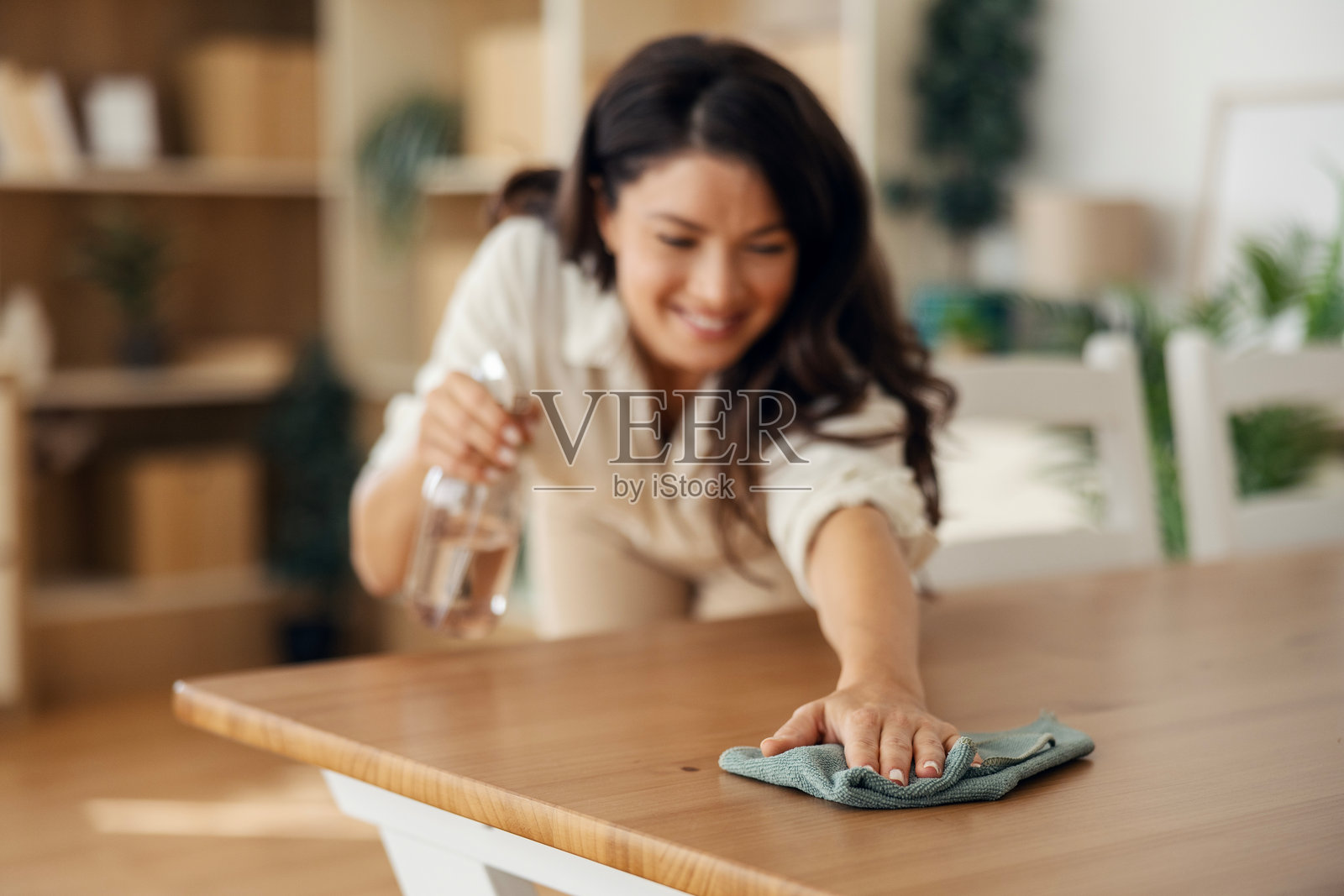 一位女士在微笑着清洁餐桌照片摄影图片