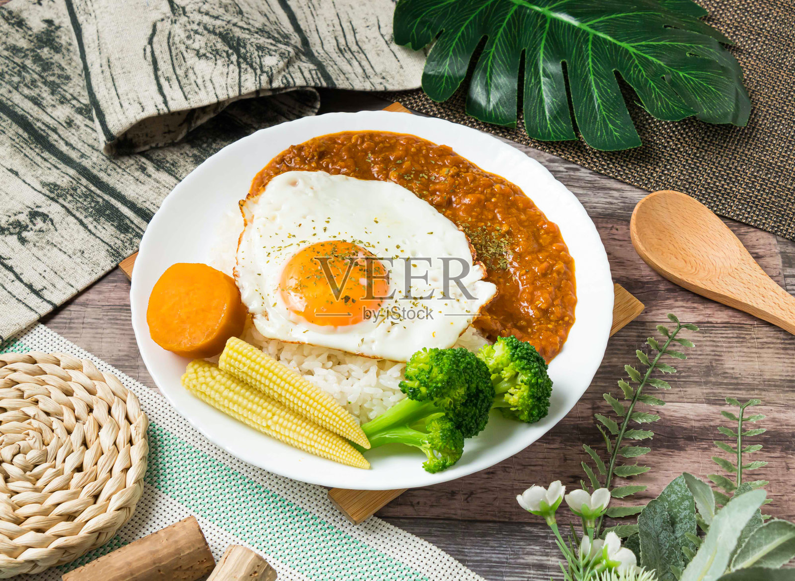 一份美味的干咖喱猪肉饭，配有煎蛋和蔬菜，是享用美味健康午餐或晚餐的理想选择。每一口都能品尝到新鲜食材和鲜活风味。照片摄影图片