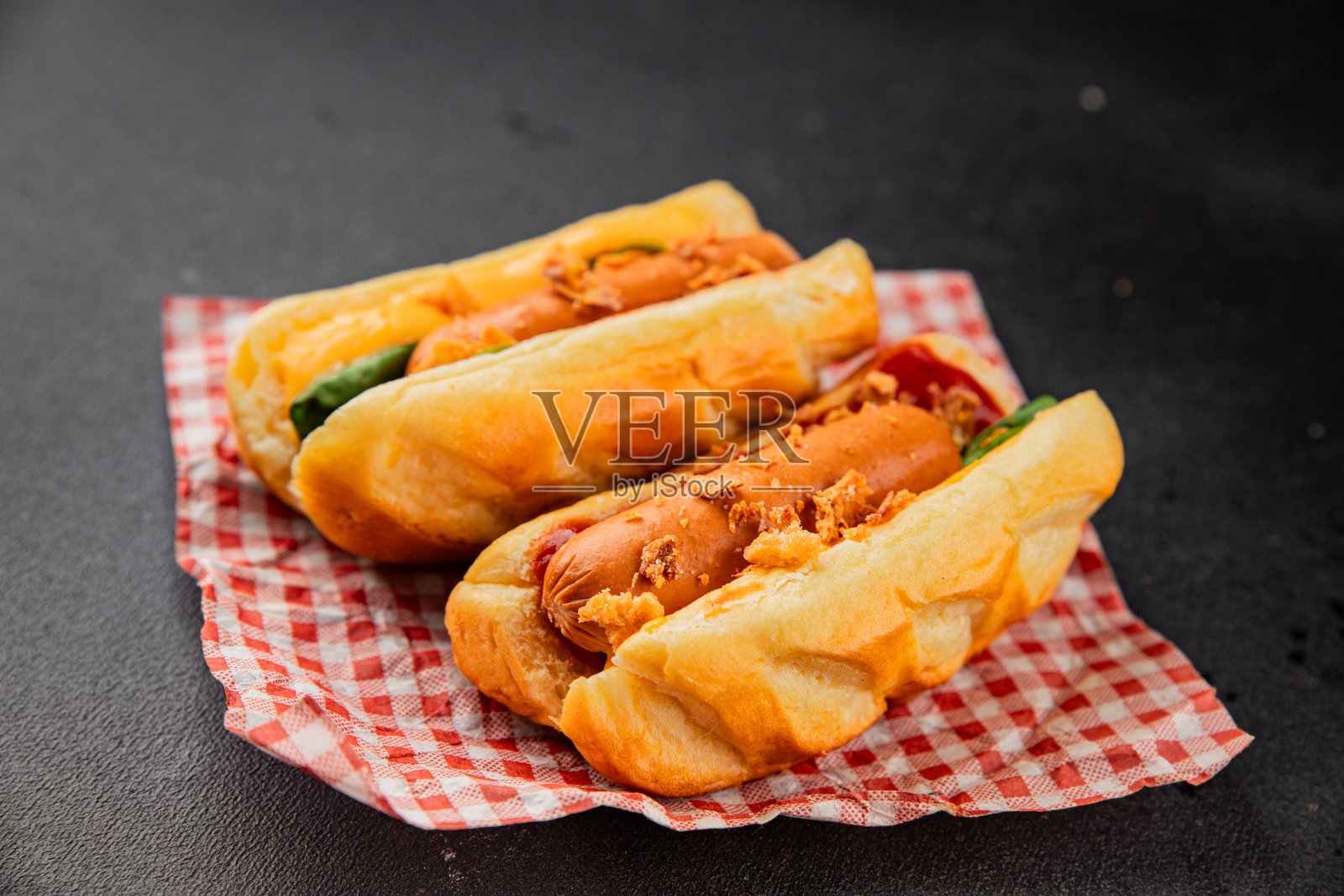 热狗配炸洋葱、香肠、面包和酱汁，美味的快餐小吃，新鲜美味的美食背景，摆放在桌上，乡村风格，俯视角度，留有复制空间照片摄影图片