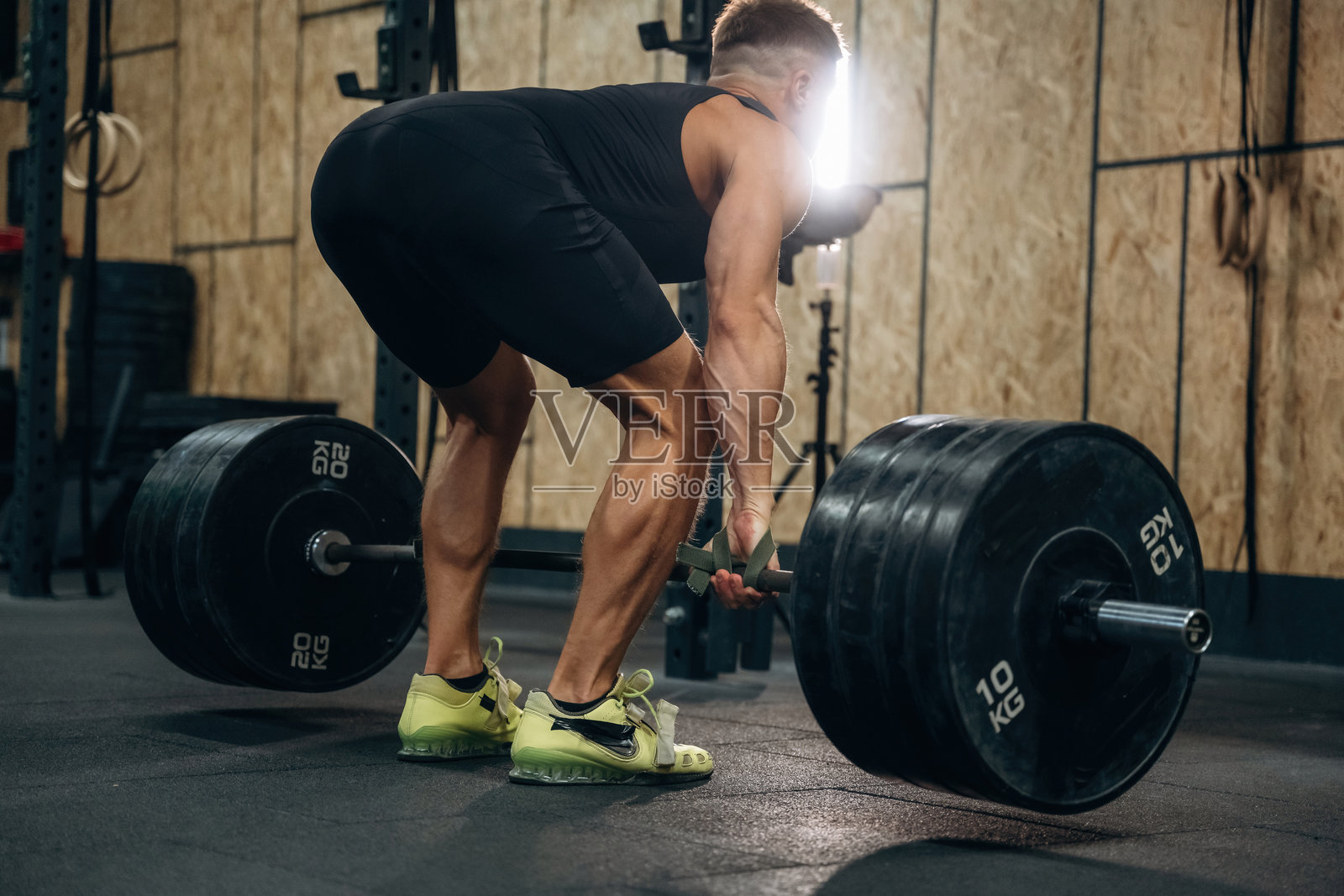 体能训练的男人在健身房举杠铃进行力量训练照片摄影图片