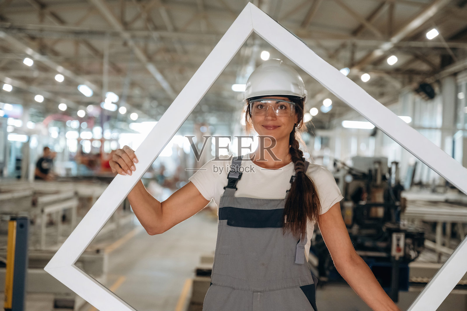 现代化门窗制造厂，一名身着职业制服的女性正在站立照片摄影图片