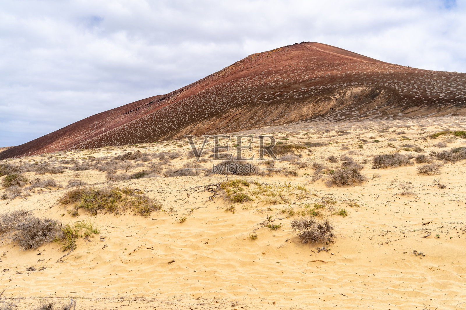 拉格拉西奥萨、兰萨罗特岛的红色山峦在沙丘地上方的风景。照片摄影图片
