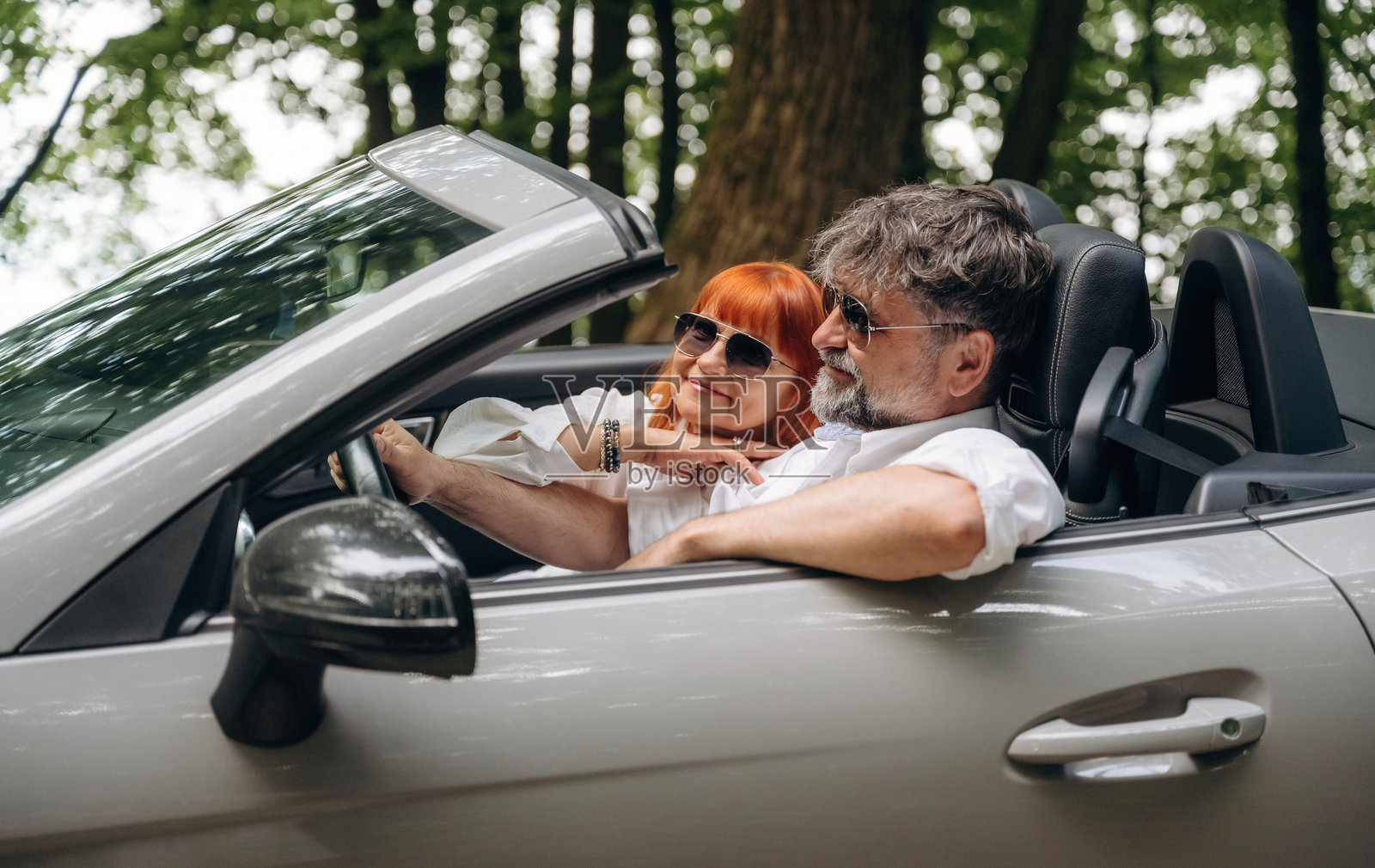 心情愉悦，准备度假。一对老年夫妇正驾驶着敞篷跑车照片摄影图片