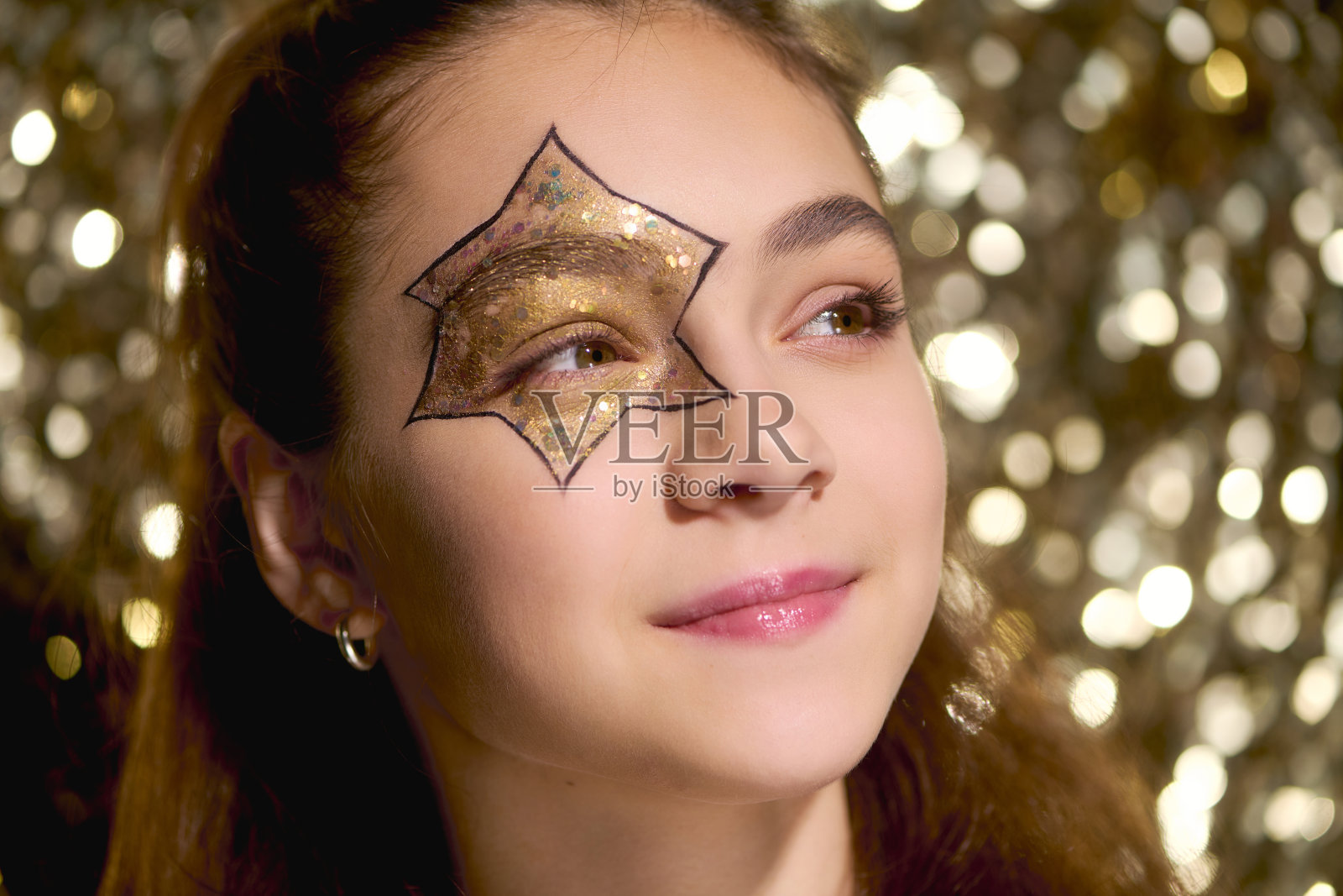 可爱的女孩脸部有星星彩绘和金色亮片装饰照片摄影图片