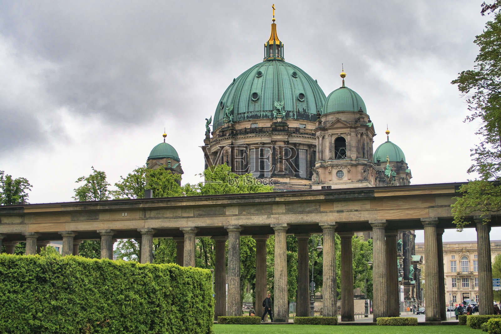 柏林大教堂，从博物馆岛上的卢斯特加滕柱廊望去 - 宏伟的柏林大教堂（Berliner Dom）从卢斯特加滕公园（Lustgarten）望去，经典柱廊和精心修剪的绿色树篱构成了画面框架。照片摄影图片