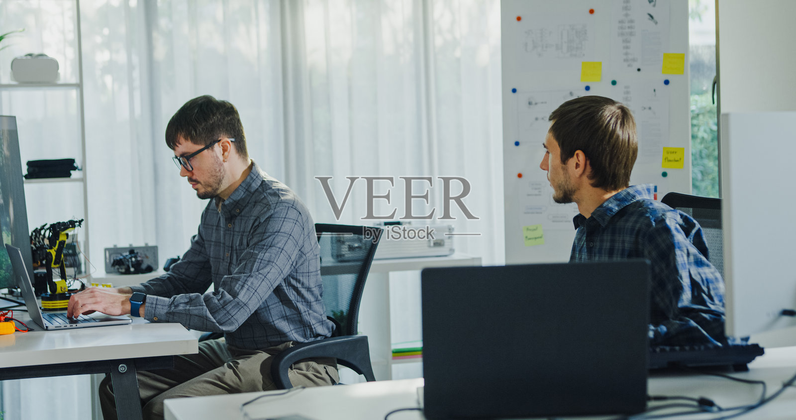 成年男性工程师团队在科技工作空间讨论人工智能软件开发机器人手臂项目，使用人工智能代码解决方案。人工智能界面，协作支持原型开发。照片摄影图片