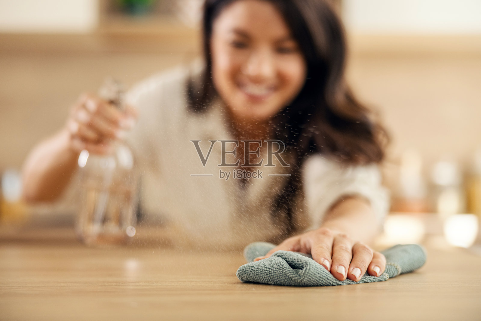 女子喷洒并擦拭厨房台面以保持清洁照片摄影图片