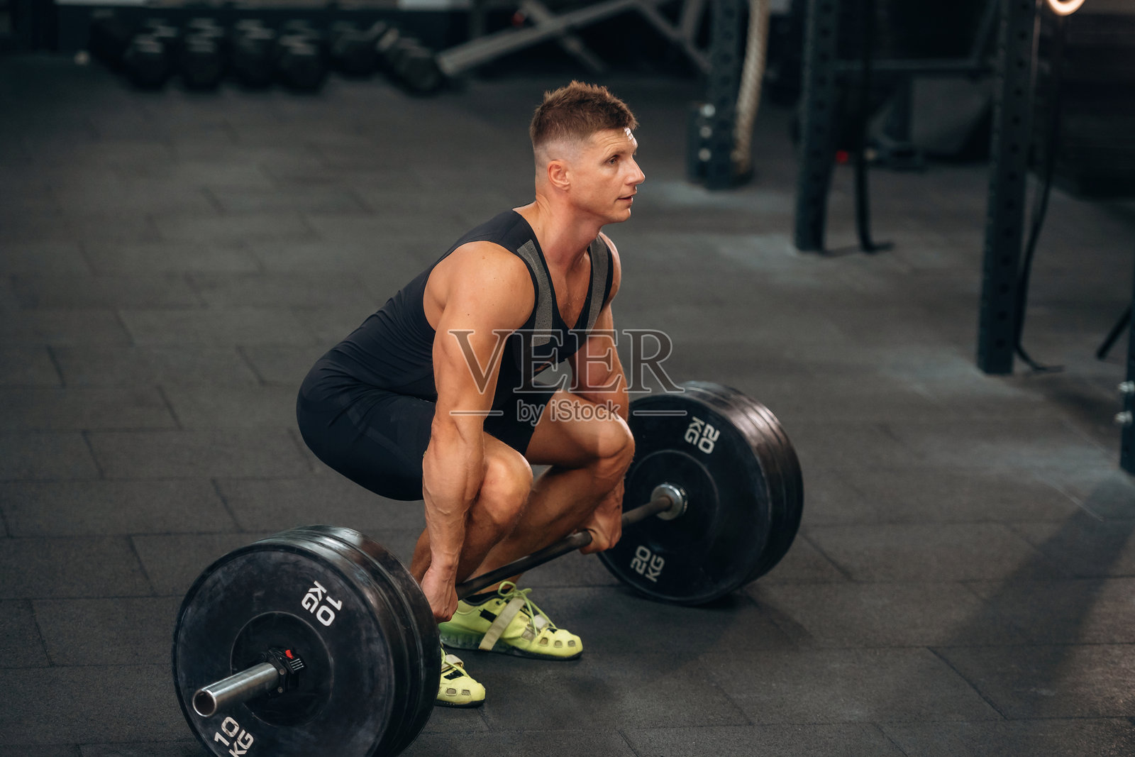 坐姿，准备深蹲。运动男子在健身房用杠铃进行举重训练照片摄影图片
