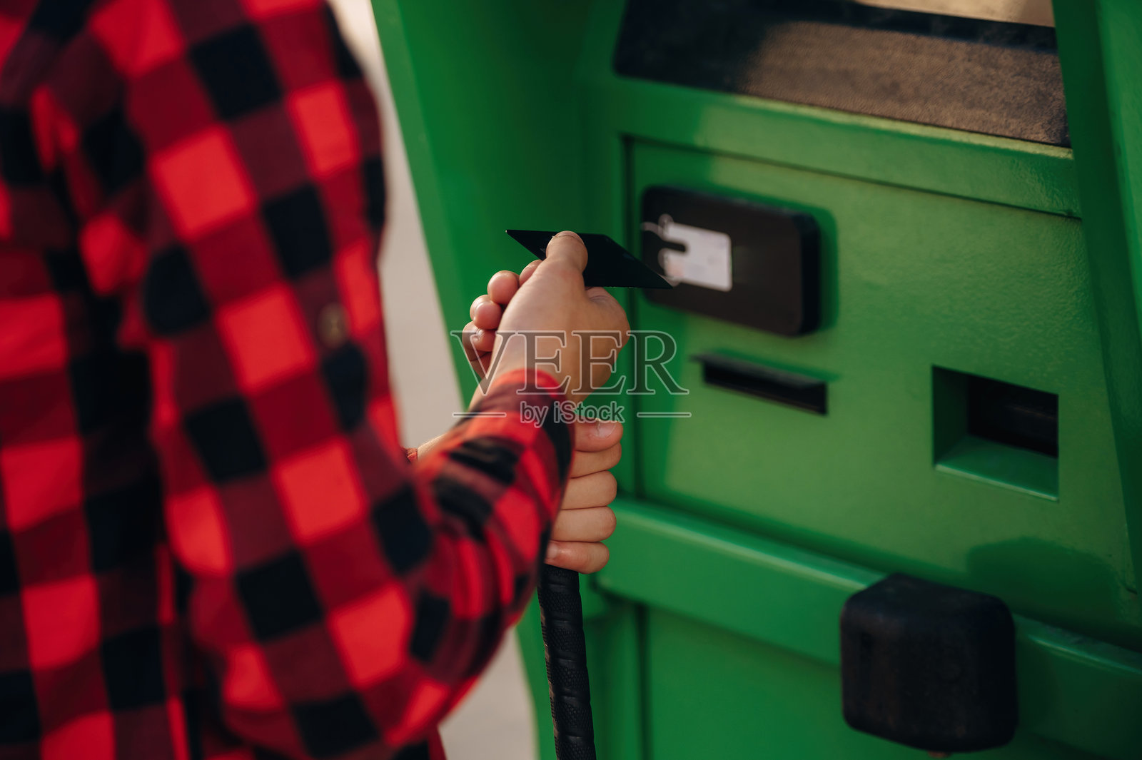 特写：一名使用白色手杖的男子正在ATM机上刷信用卡照片摄影图片