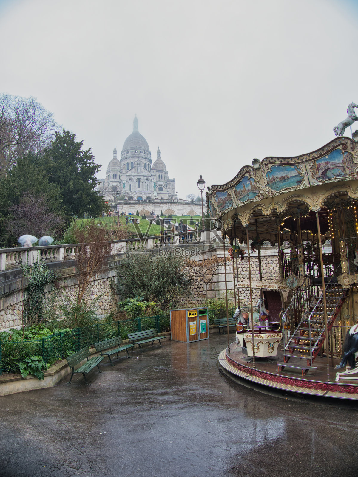 圣心大教堂和蒙马特旋转木马 - 罗马天主教大教堂和美丽的传统旋转木马的标志性景观，在雨雾天气下的巴黎历史街区。照片摄影图片