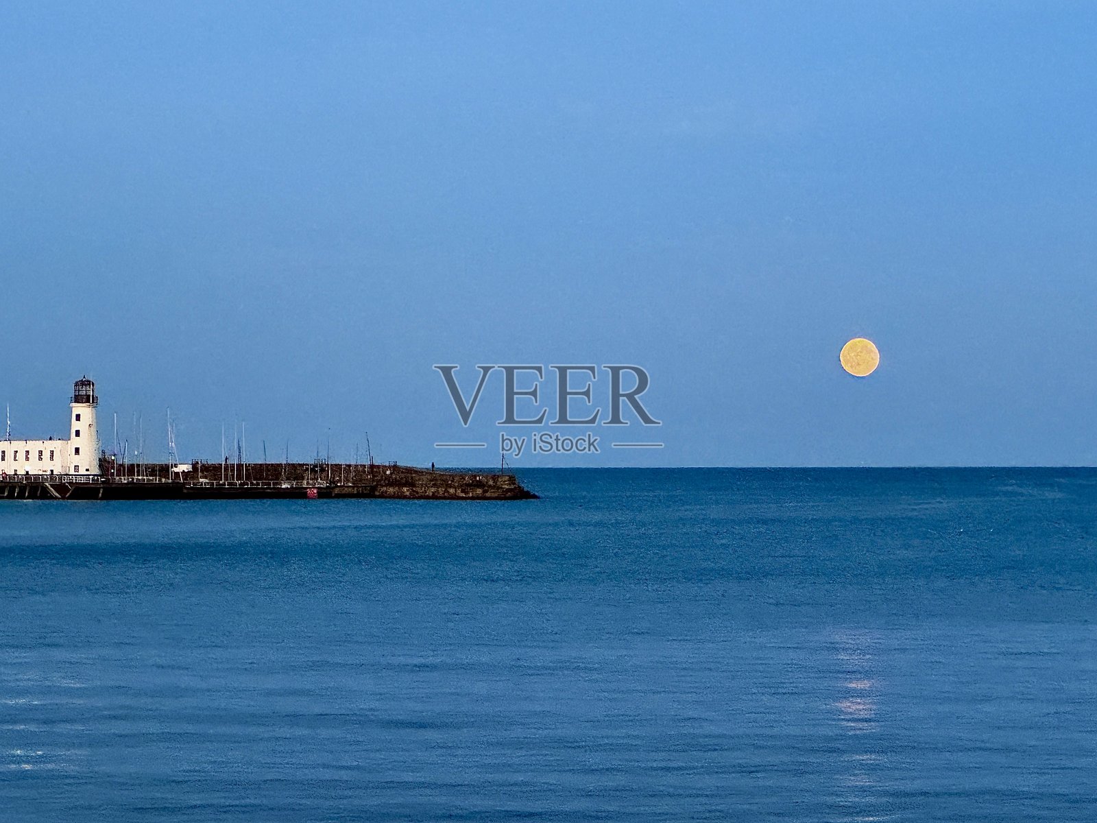 北约克郡斯卡伯勒灯塔旁的一轮硕大的丰收之月照片摄影图片