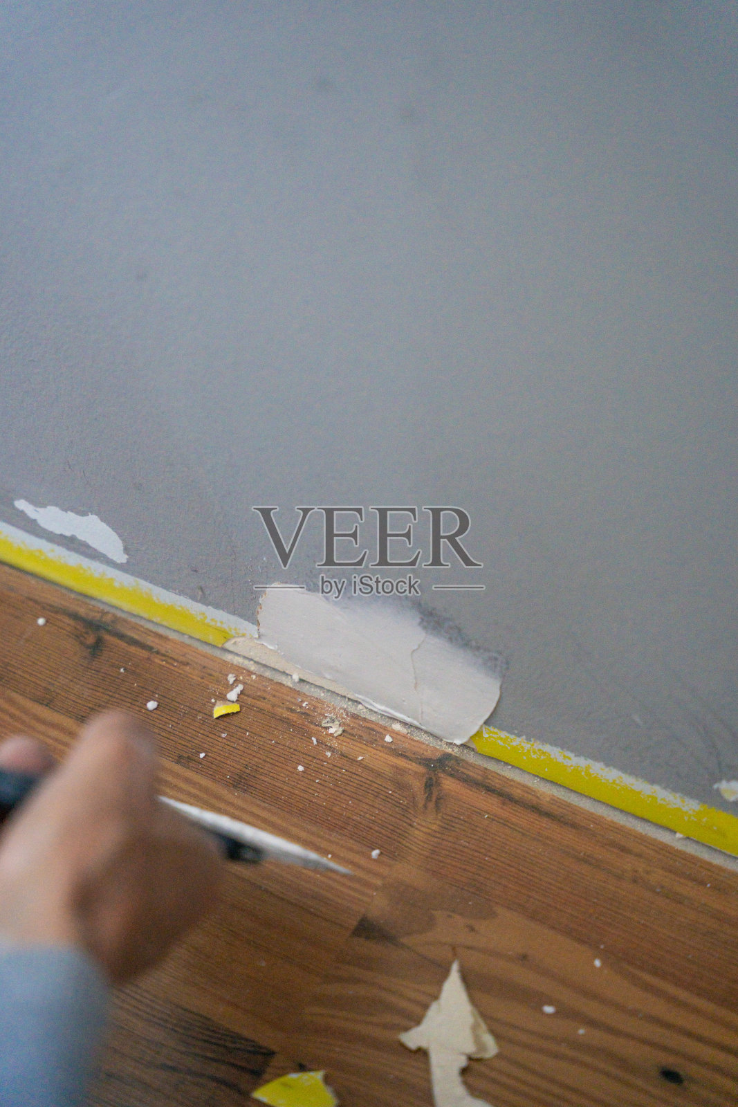 用抹刀和刮刀修复靠近木地板的破损墙壁照片摄影图片