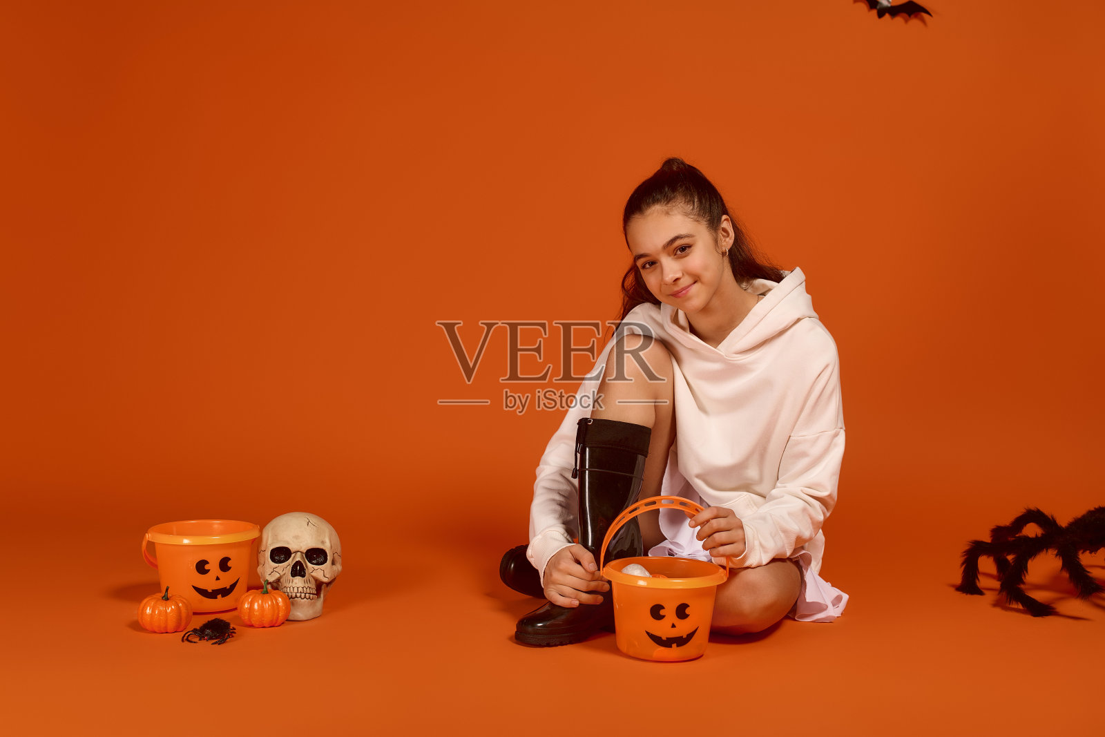 可爱的小女孩在充满活力的橙色背景中享受万圣节的节日气氛照片摄影图片
