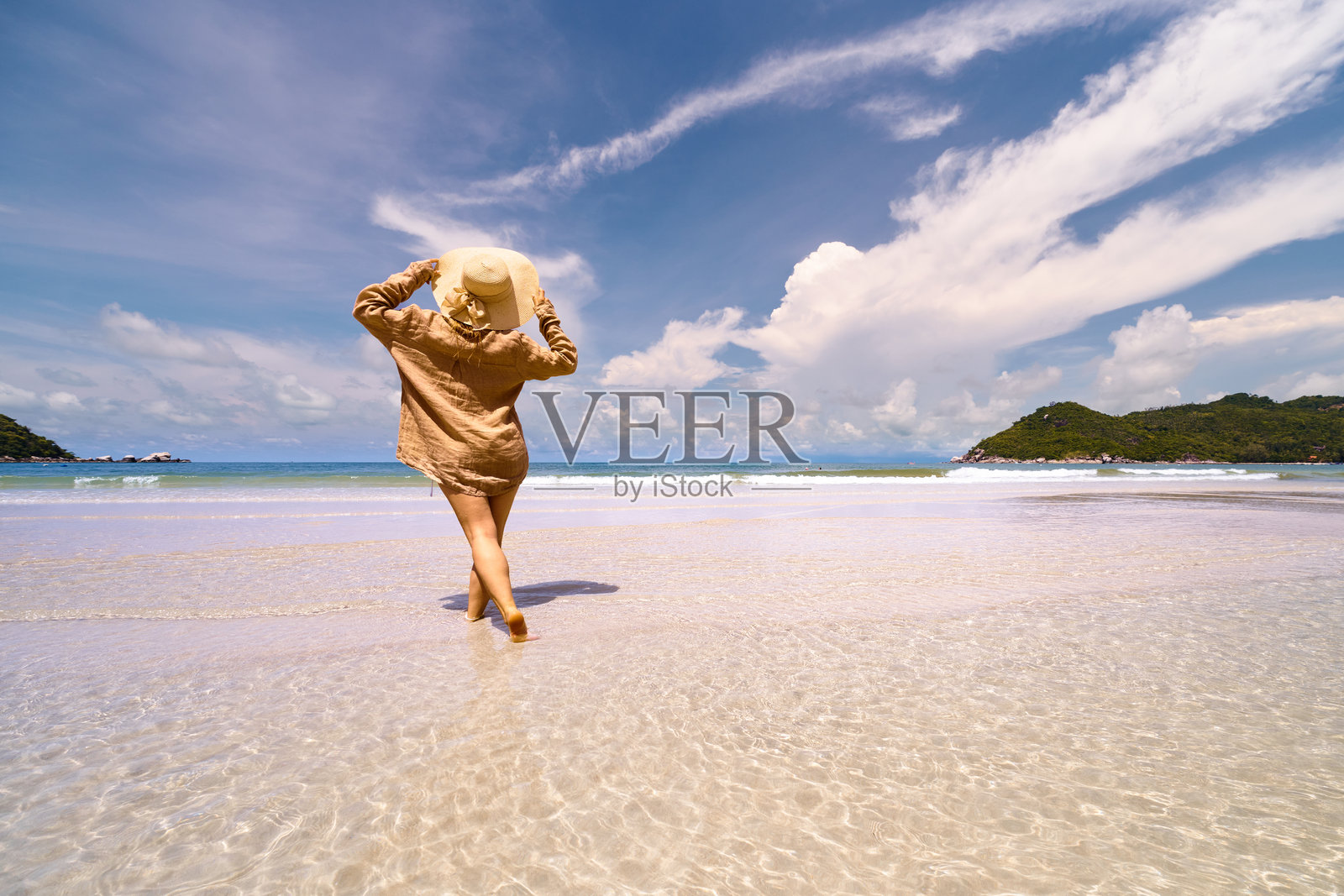 女人漫步在热带海滩上，享受夏日假期照片摄影图片