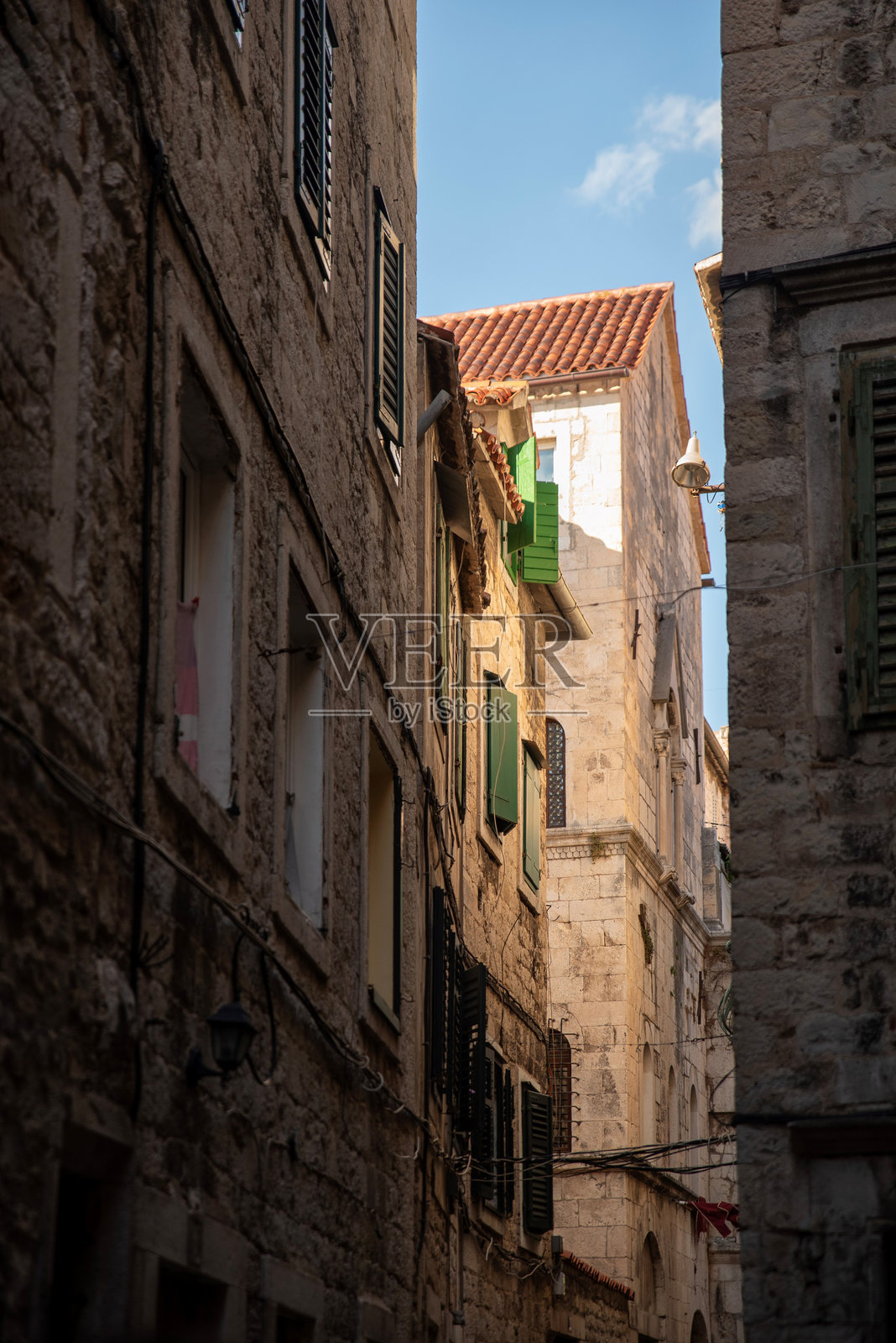 狭窄的老城区小巷，配有绿色的百叶窗照片摄影图片