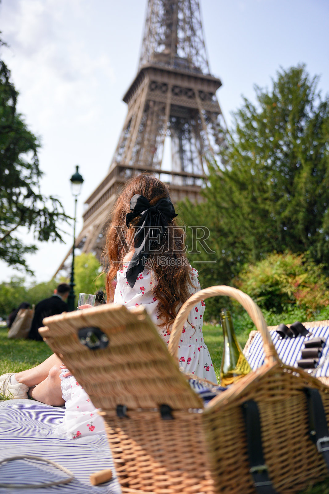 在巴黎公园埃菲尔铁塔附近的野餐女子照片摄影图片