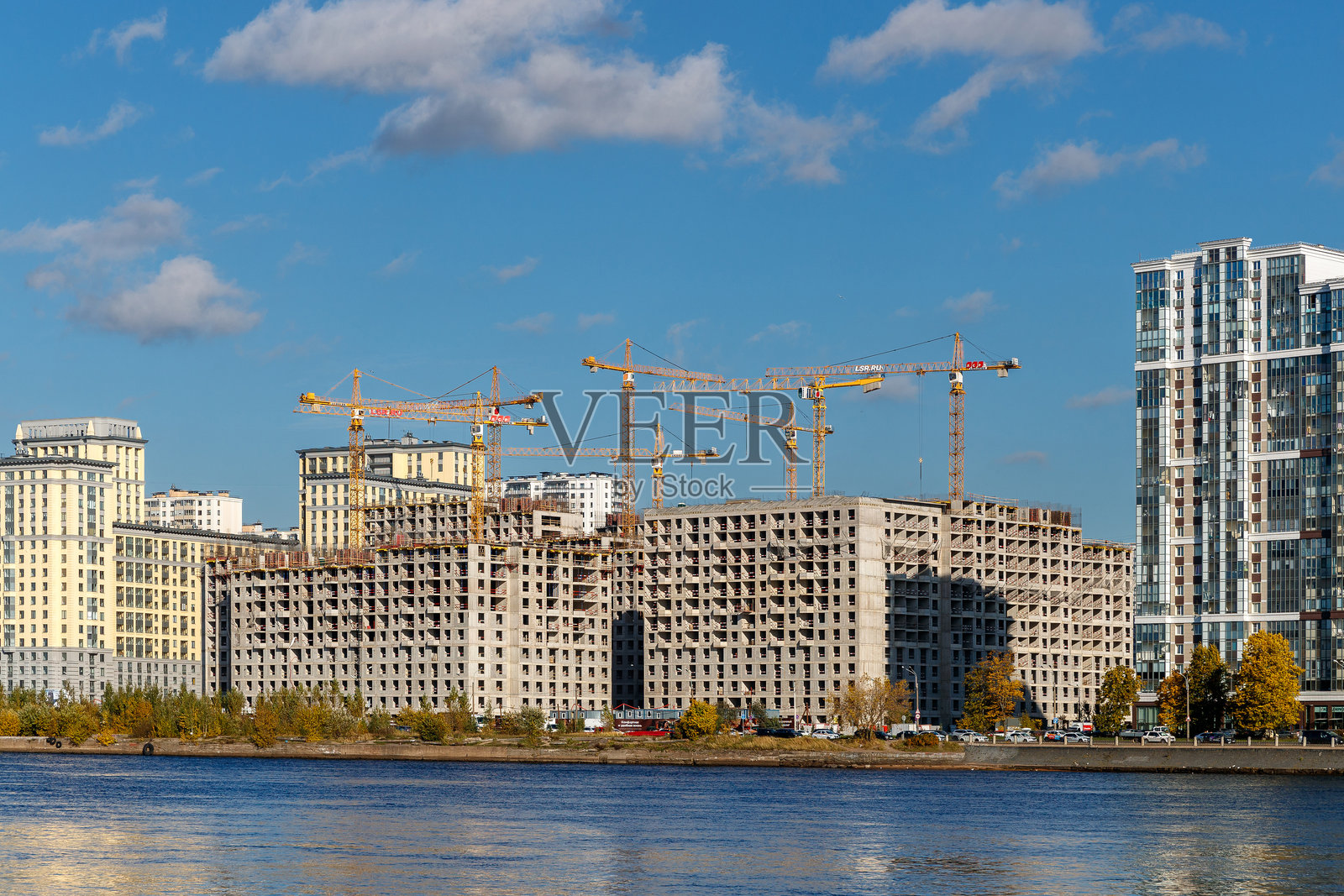 俄罗斯圣彼得堡,“涅瓦河文明”住宅区的建筑工地,蓝天下有高耸的塔式起重机照片摄影图片