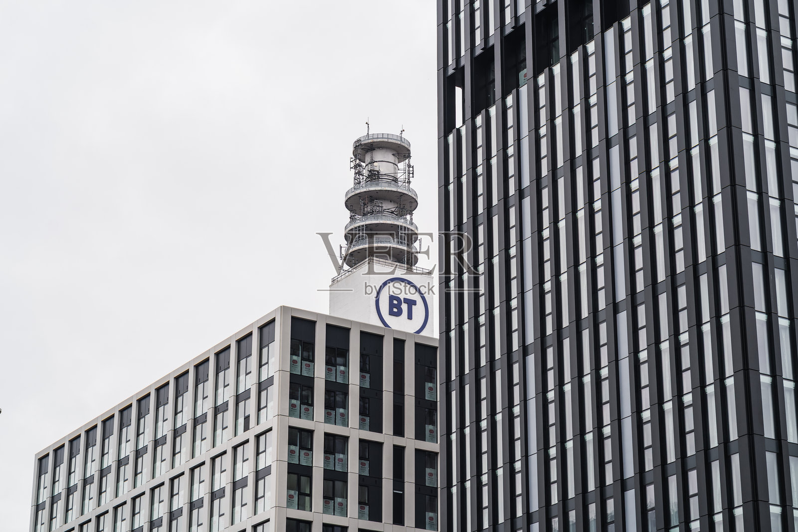 向上看办公楼外观，背景是BT塔照片摄影图片