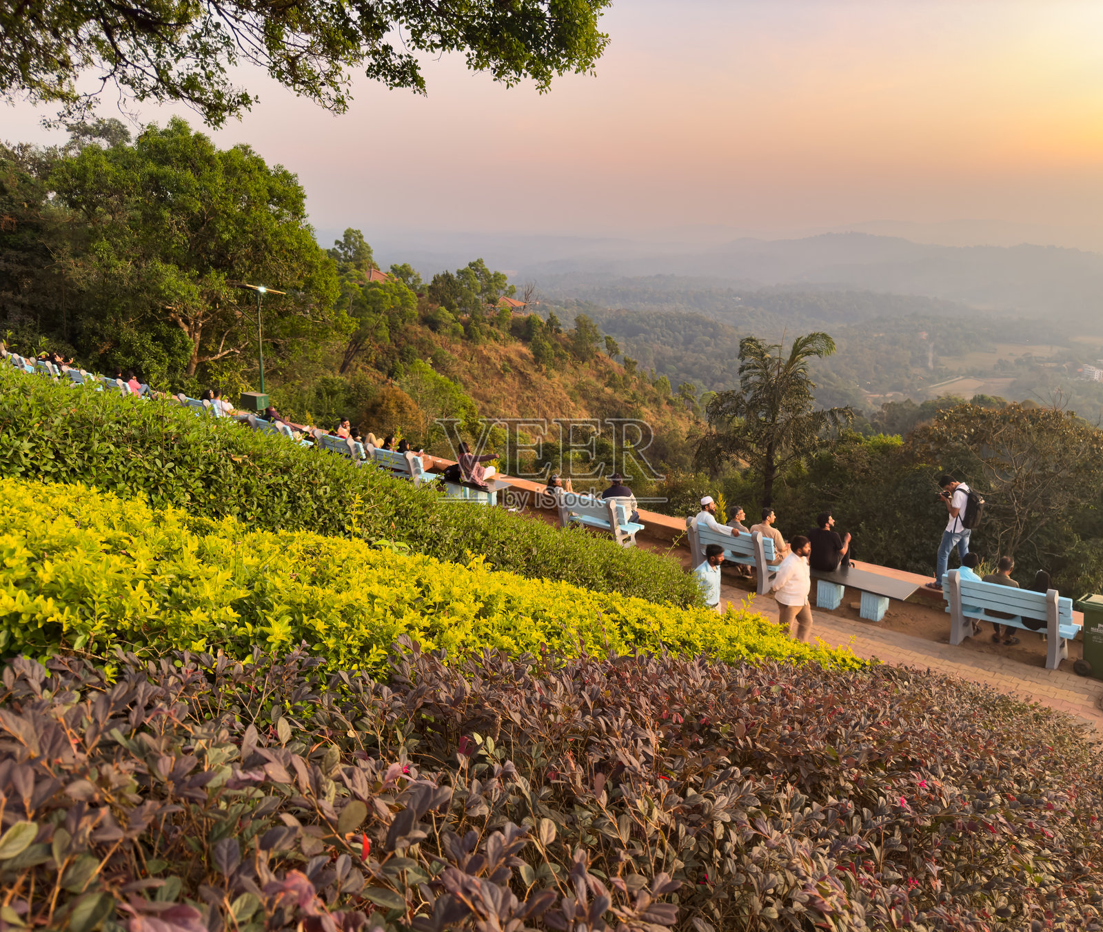 游客在科格区马迪凯里颇受欢迎的旅游景点——国王宝座 (Raja's Seat) 欣赏日落美景。照片摄影图片