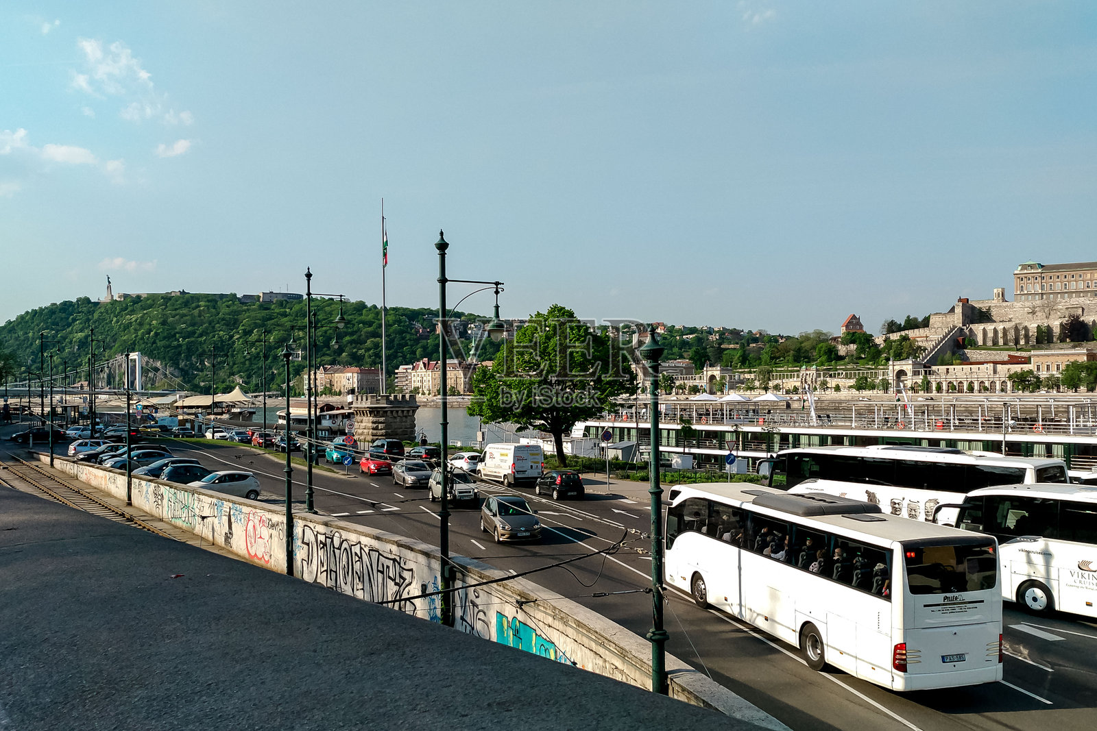 晴朗天空下，繁忙的城市河滨，车水马龙，历史建筑林立照片摄影图片