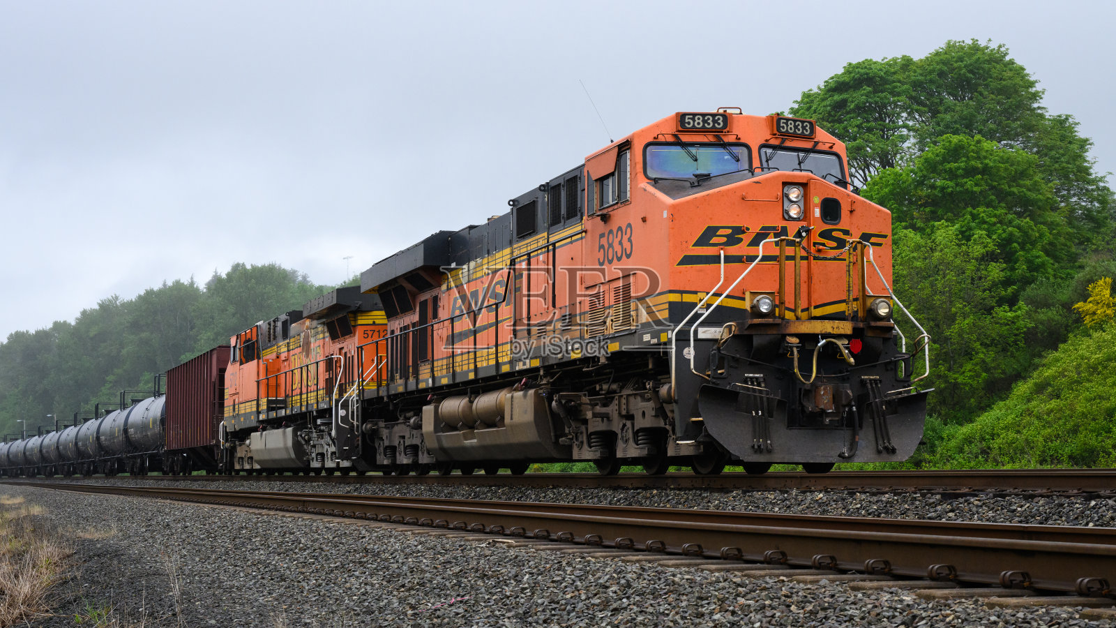 BNSF GE ES44AC 型机车在雨天牵引油罐列车照片摄影图片