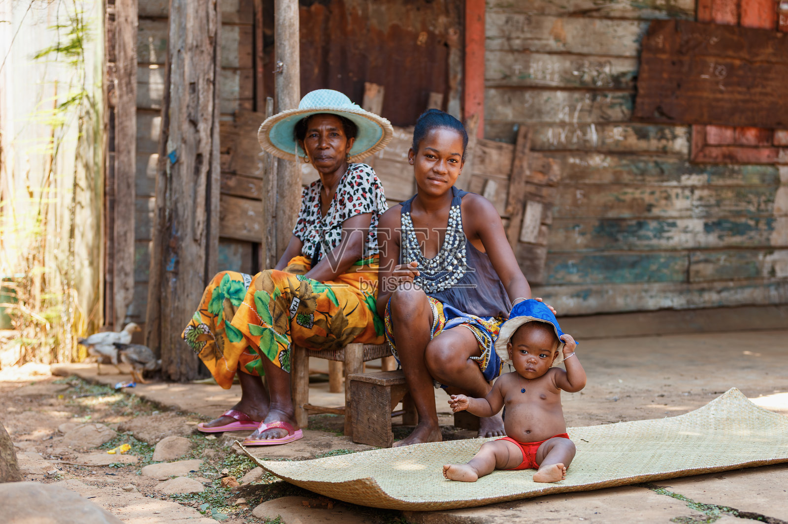 马达加斯加图阿马西纳省布里克维尔的家庭成员，他们坐着和站着，身处自家木屋前照片摄影图片
