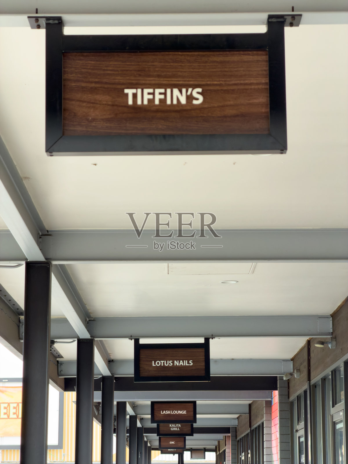 现代购物走廊里悬挂的标示着商家的招牌照片摄影图片