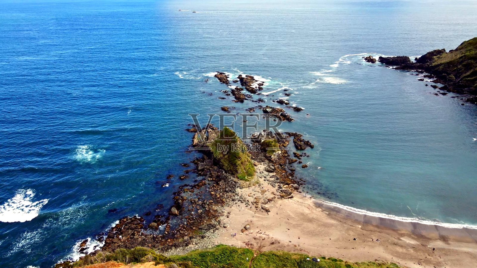 宁静的蓝色海岸线上，有岩石连岛沙洲和海蚀柱照片摄影图片