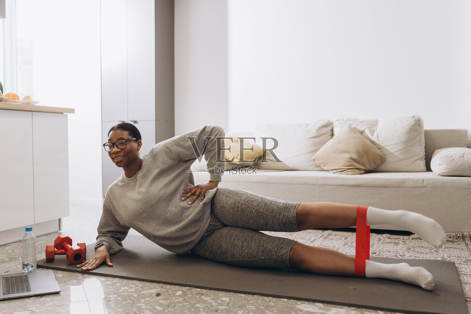 年轻的黑人女性在家中使用弹力带锻炼照片摄影图片