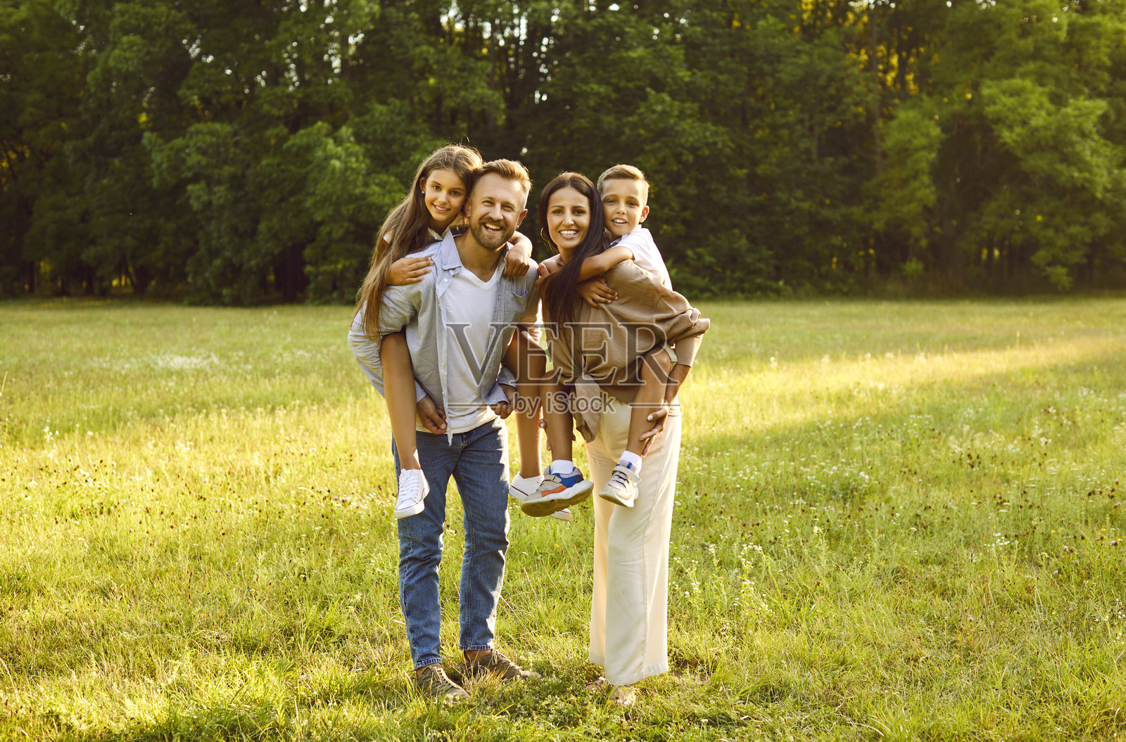 快乐的父母和孩子们在夏天的绿色公园里享受着宝贵的时光照片摄影图片