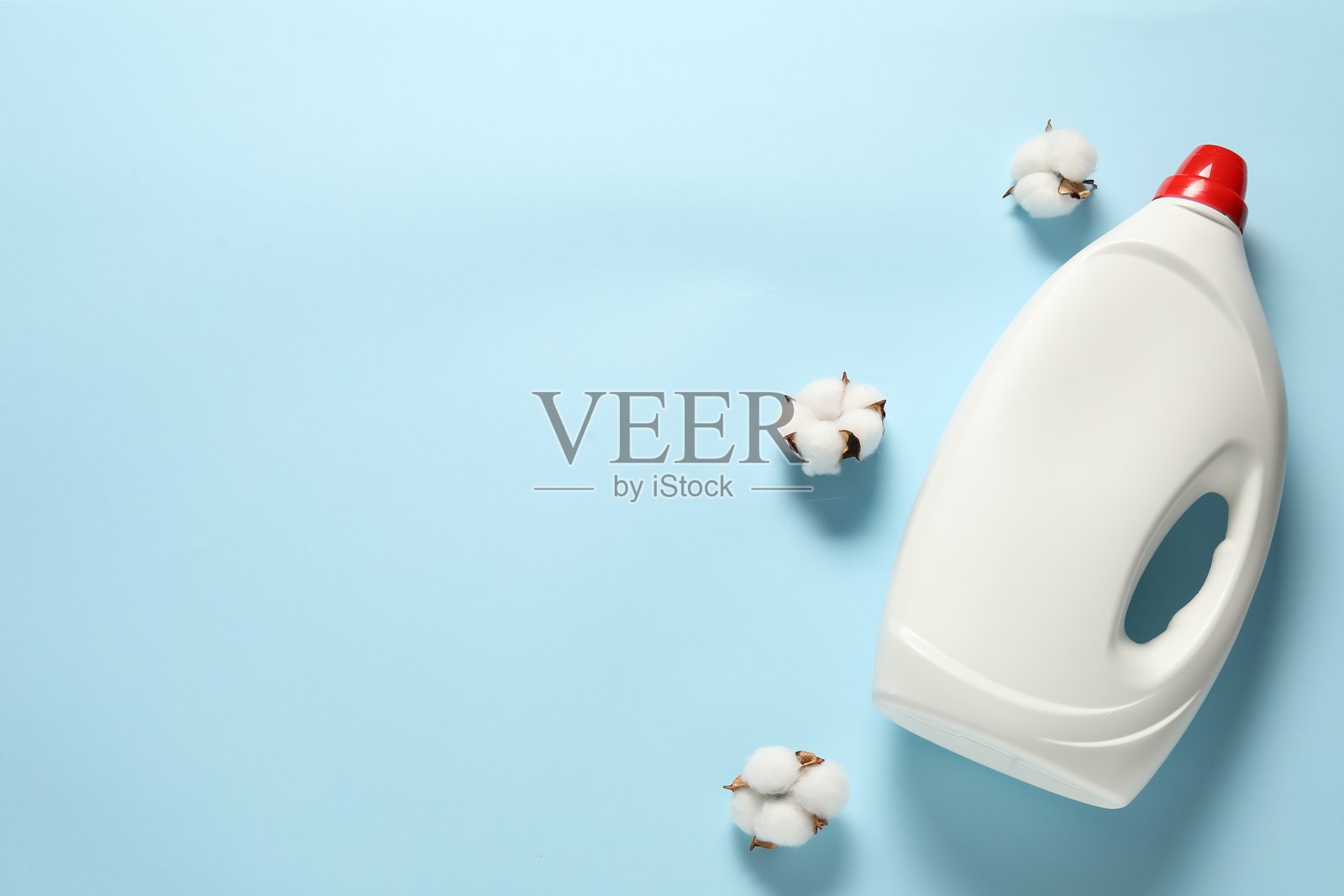 浅蓝色背景上的洗衣液瓶和棉花，俯视角度。留有文字空间照片摄影图片