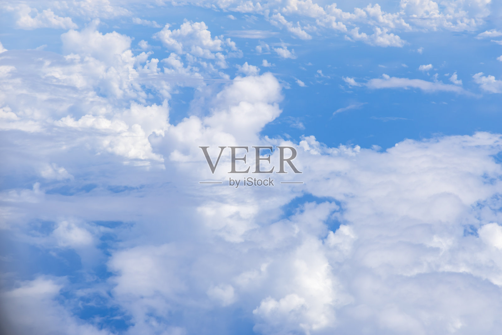 白天飞行时从飞机舷窗看到的层叠云层照片摄影图片