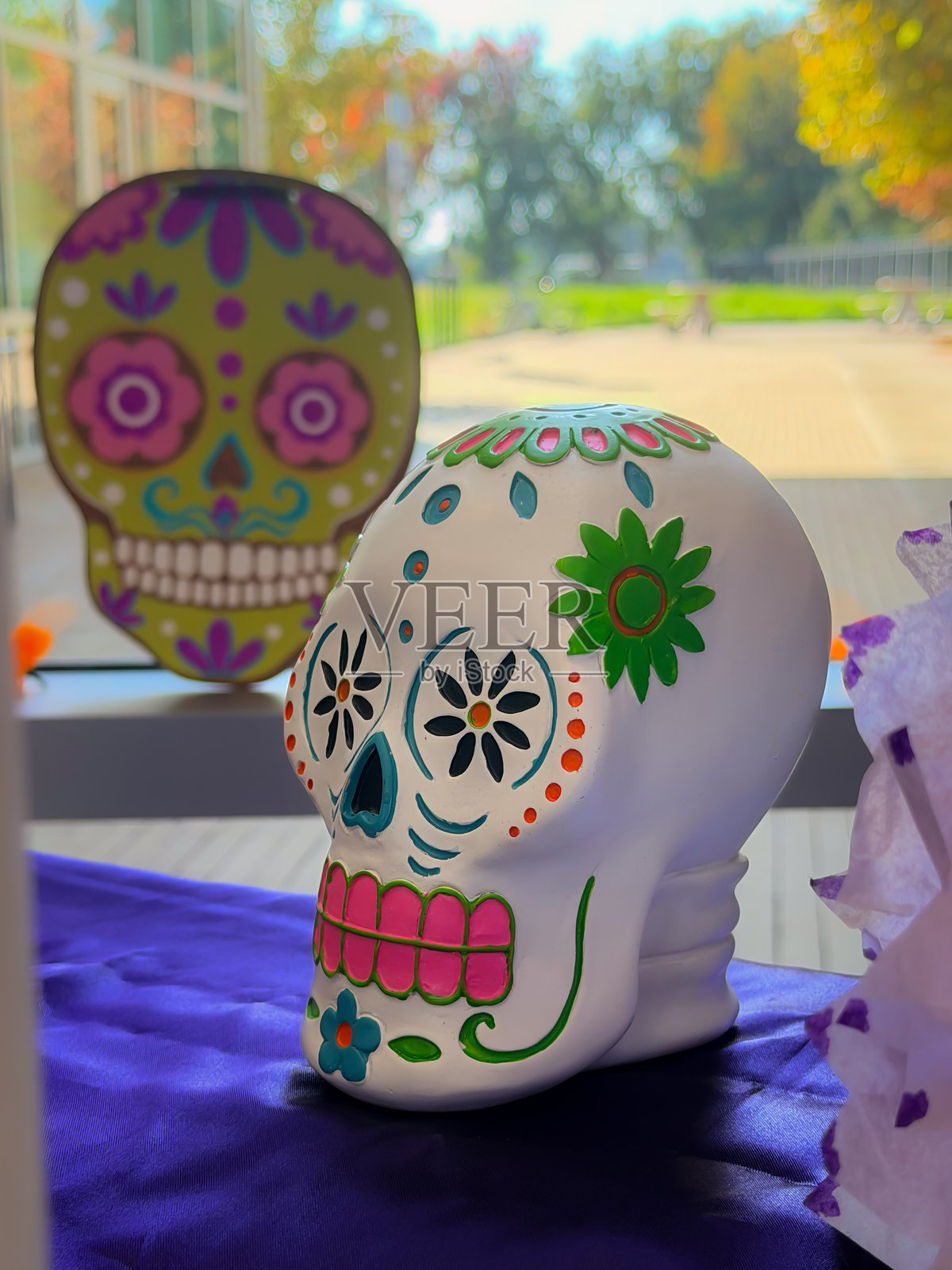 秋日阳光下户外节庆活动中色彩缤纷的糖骷髅头和装饰艺术展示照片摄影图片