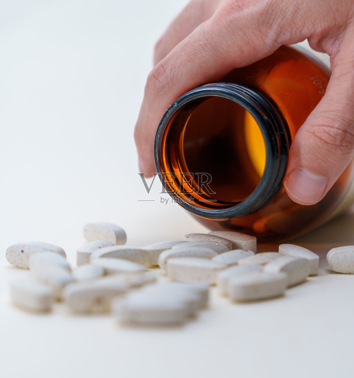 用药概念：玻璃容器和散落的药片照片摄影图片