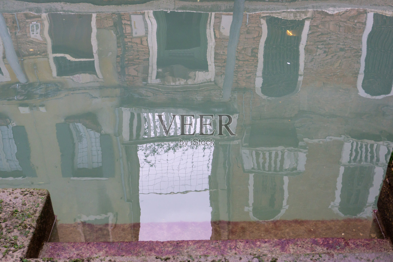 威尼斯水城，运河水面上倒映着古老建筑的石头台阶被洪水淹没照片摄影图片